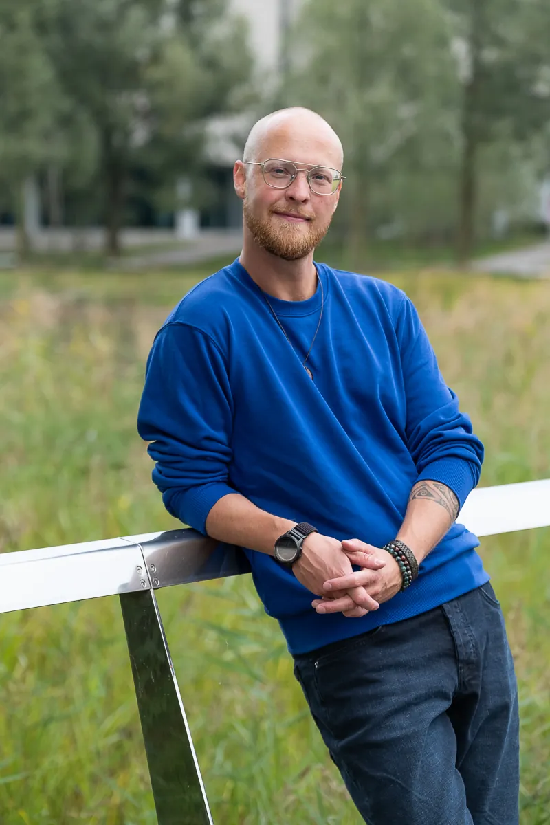 Merlijn Linschooten, fractional CMO for deep tech, leaning on a railing at High Tech Campus Eindhoven
